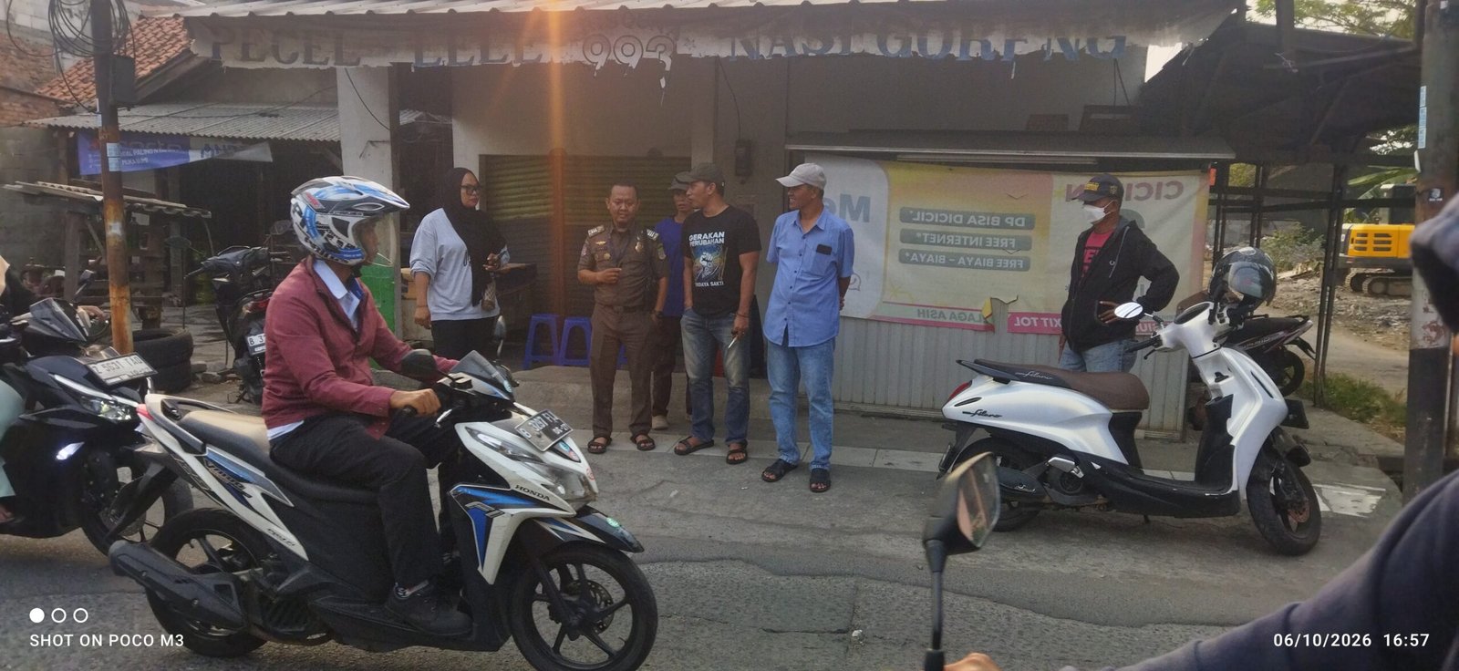 Kades terpilih Tridaya Sakti, Sopian, S.E. (Kemeja Jeans biru, topi putih) bersama Satpol PP dan Tokoh Pemuda sekitar saat melakukan pengecekan proses perbaikan jalan Simpang Lima KH. Mas'ud, Selasa (6/10/2026). 